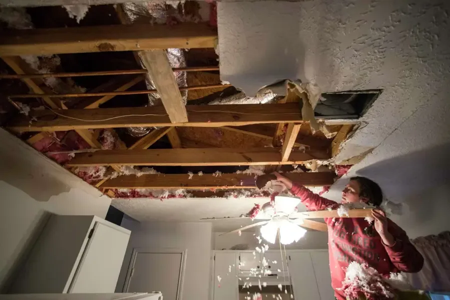 Wet insulation pulled down from an opened ceiling after a pipe above it froze